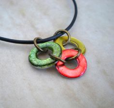 three different colored circles on a black leather necklace