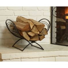 a pile of firewood sitting on top of a metal stand next to a fireplace