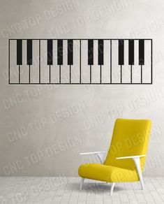 a yellow chair sitting in front of a wall with piano keys on it's side