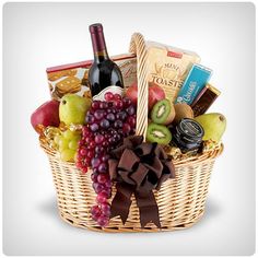 a wicker basket filled with assorted fruit and wine