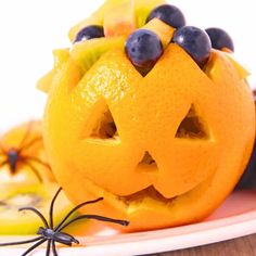 an orange with blueberries in the shape of a jack - o'- lantern