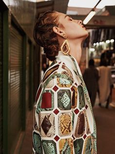 a woman with her eyes closed standing in an alley