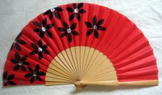 a red fan with black flowers on it