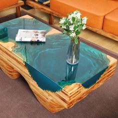 a vase with flowers sitting on top of a glass table in front of couches