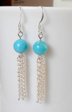 the earrings are made with silver chains and turquoise beads