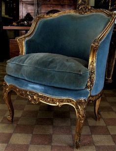 an antique chair with blue velvet upholstered on it