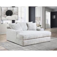 a large white couch sitting on top of a wooden floor