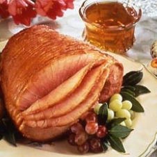 a large turkey sitting on top of a white plate next to some fruit and flowers