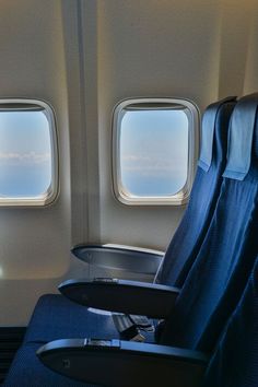 an airplane with two seats facing the window and one seat facing the other, looking out at the sky