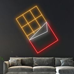 a couch sitting in front of a wall with neon lights on it