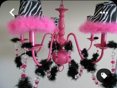 a pink chandelier with zebra print lampshade and black feathers on it