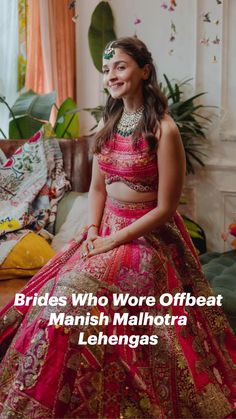 a woman in a red and gold bridal gown sitting on a couch next to a potted plant