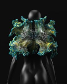 a mannequin's torso covered in green and yellow art work on black background