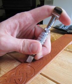 a person is working on some kind of carving with wood and metal tools in their hand