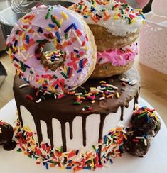 three donuts are stacked on top of each other with chocolate frosting and sprinkles