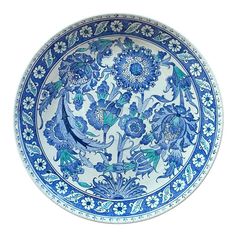 a blue and white plate with floral designs on the bottom, sitting in front of a white background