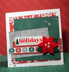 a christmas card with a red poinsettie on the front and green background