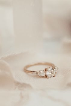 an engagement ring with three pears in the background