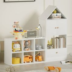 there is a white shelf with toys on it in the room next to bookshelves