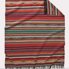 a multicolored blanket with fringes on it