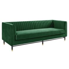 a green velvet sofa with black legs and gold trimmings on the armrests