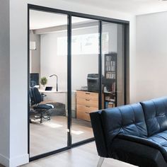 a living room filled with furniture and a sliding glass door that leads to an office