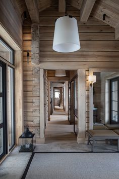 an empty room with wooden walls and flooring is seen in this image, there are two benches on either side of the hallway