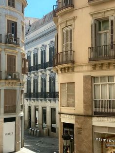 several buildings with balconies and people walking on the sidewalk