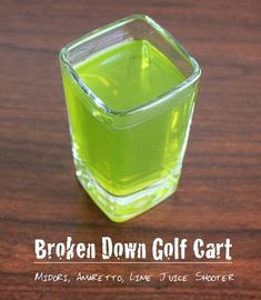 a glass container filled with green liquid on top of a wooden table