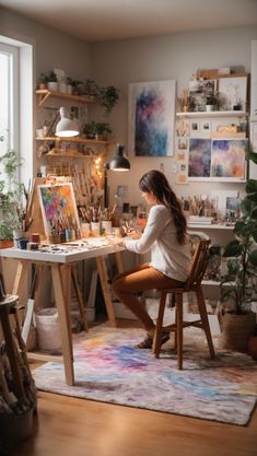 a woman sitting at a desk in front of an easel with paint and brushes on it