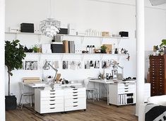 an office with white desks and shelves on the wall