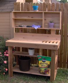 a wooden potting bench sitting in the grass