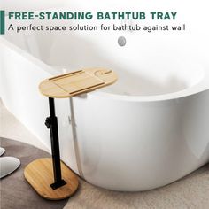 a free standing bathtub tray is on the floor next to a white tub with a wooden stand