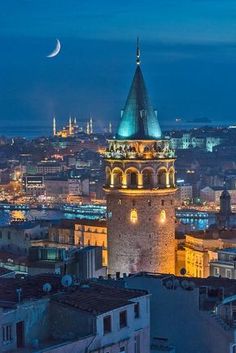 the moon is setting over an old city at night with tall buildings in the foreground