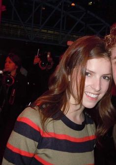 a man and woman are posing for a photo in front of the camera at a concert