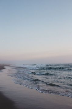 an ocean beach with waves coming in to shore