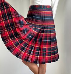 "Stunning vintage 1970s-80s Highland Queen knife pleated A-line midi-skirt in the best plaid colour palette - with red, black, blue, green and yellow. The skirt is a very nice quality wool and features two buttons with zipper closure at the side of the waist (buttons in two places). Would fit a size Medium with 30\" waist - model is size 2 and 5'8 for reference and skirt is pinned at the back in photos - please see exact measurements below. Designer: Highland Queen - Made in Canada Fabric: 100% Retro A-line Winter Skirt, Fitted Accordion Pleat Skirt For Winter, Vintage Fitted Mini Pleated Skirt, Fitted Vintage Mini Pleated Skirt, Scottish Style Fitted Pleated Skirt For Fall, Retro Plaid Pleated Skirt For Fall, Fall Scottish Pleated Skirt, Red Pleated Winter Skirt, Classic Red Winter Skirt