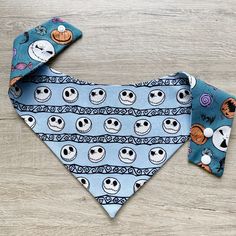 two bandanas with skulls on them are laying on a wooden surface, one is blue and the other has black eyes