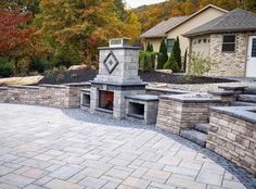 a brick patio with an outdoor fireplace and seating area