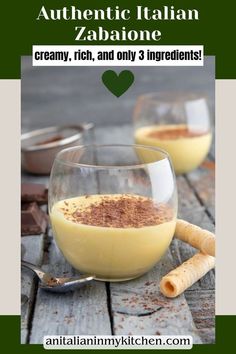 two glasses filled with liquid sitting on top of a wooden table next to spoons