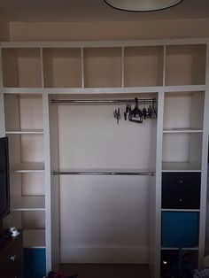 a living room with a large white bookcase next to a tv