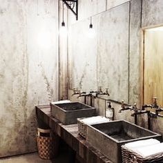 two sinks in a bathroom with mirrors above them and baskets under the sinks on either side