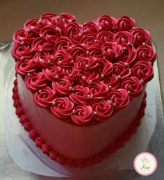 a heart - shaped cake with red icing and pearls on top is shown in the shape of a flower