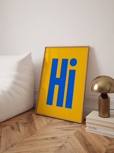 a yellow and blue sign sitting on top of a wooden floor next to a lamp