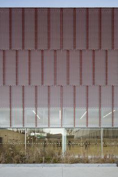 an empty bench sitting in front of a building with red and white stripes on it