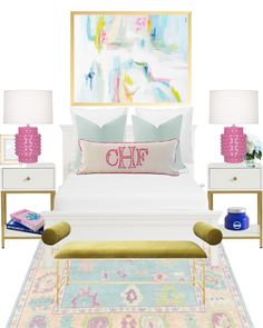 a white bed with pink and blue pillows on top of it next to two lamps