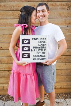 a man and woman standing next to each other holding a sign that says endless love, prayer, and a little science library