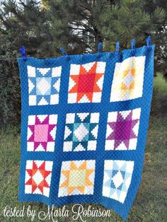 a blue quilt with stars on it in the grass