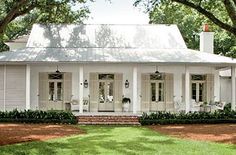 a white house sitting on top of a lush green field