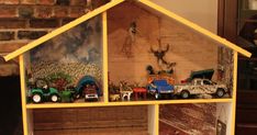 a doll house made out of wood with toy trucks and farm animals in the front